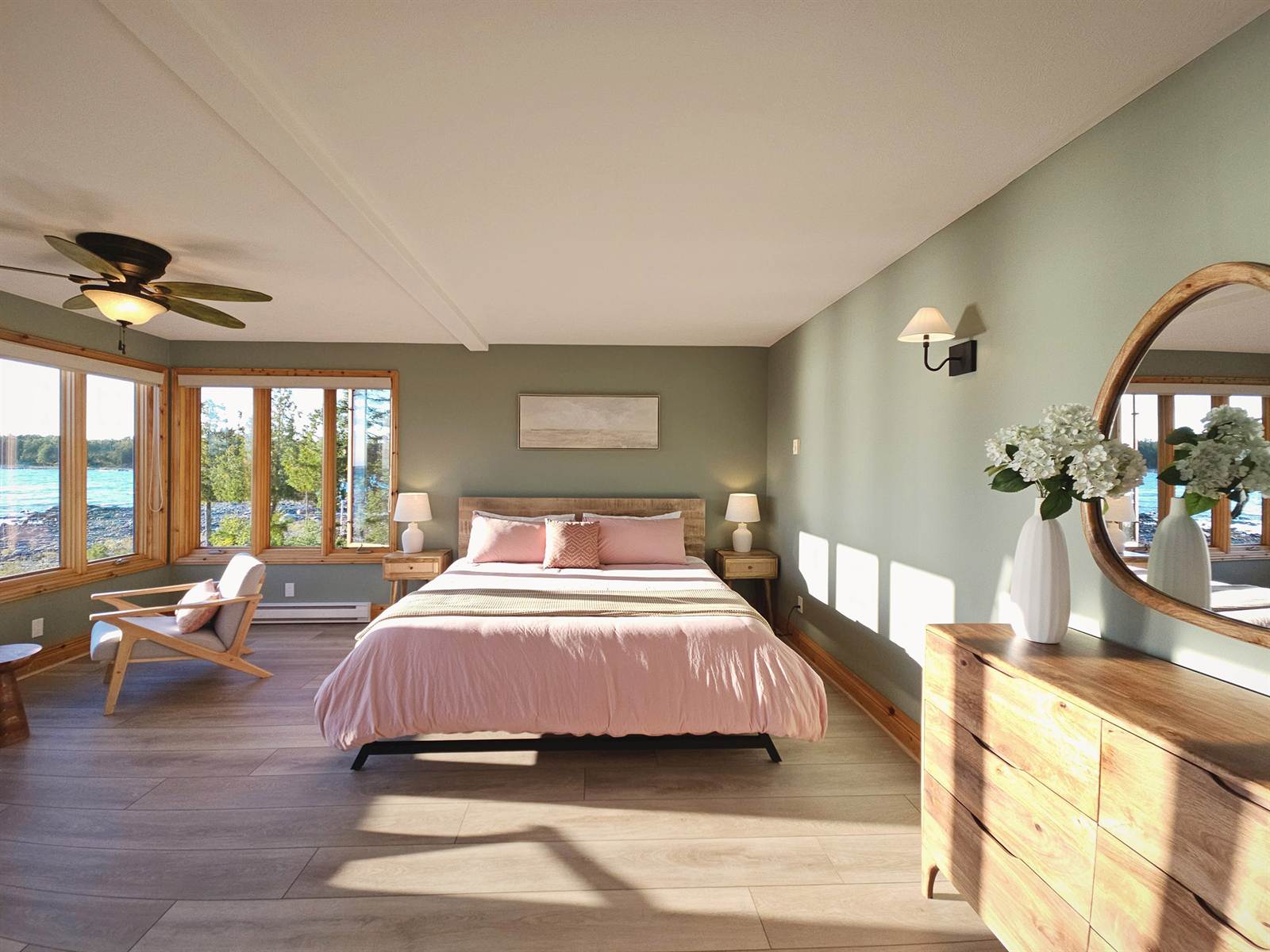 Delfina bedroom with king bed, sage walls and corner windows onto the lake