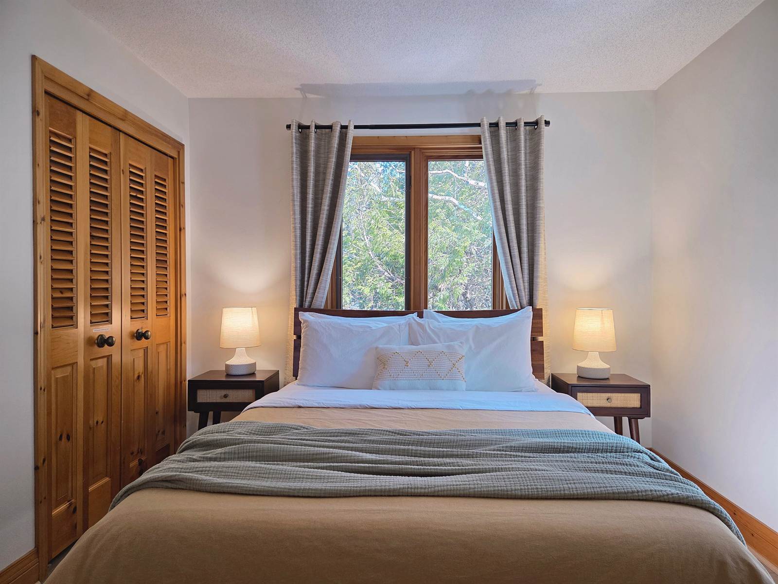 Alba bedroom with queen bed in linen and sage between two lit nightstands